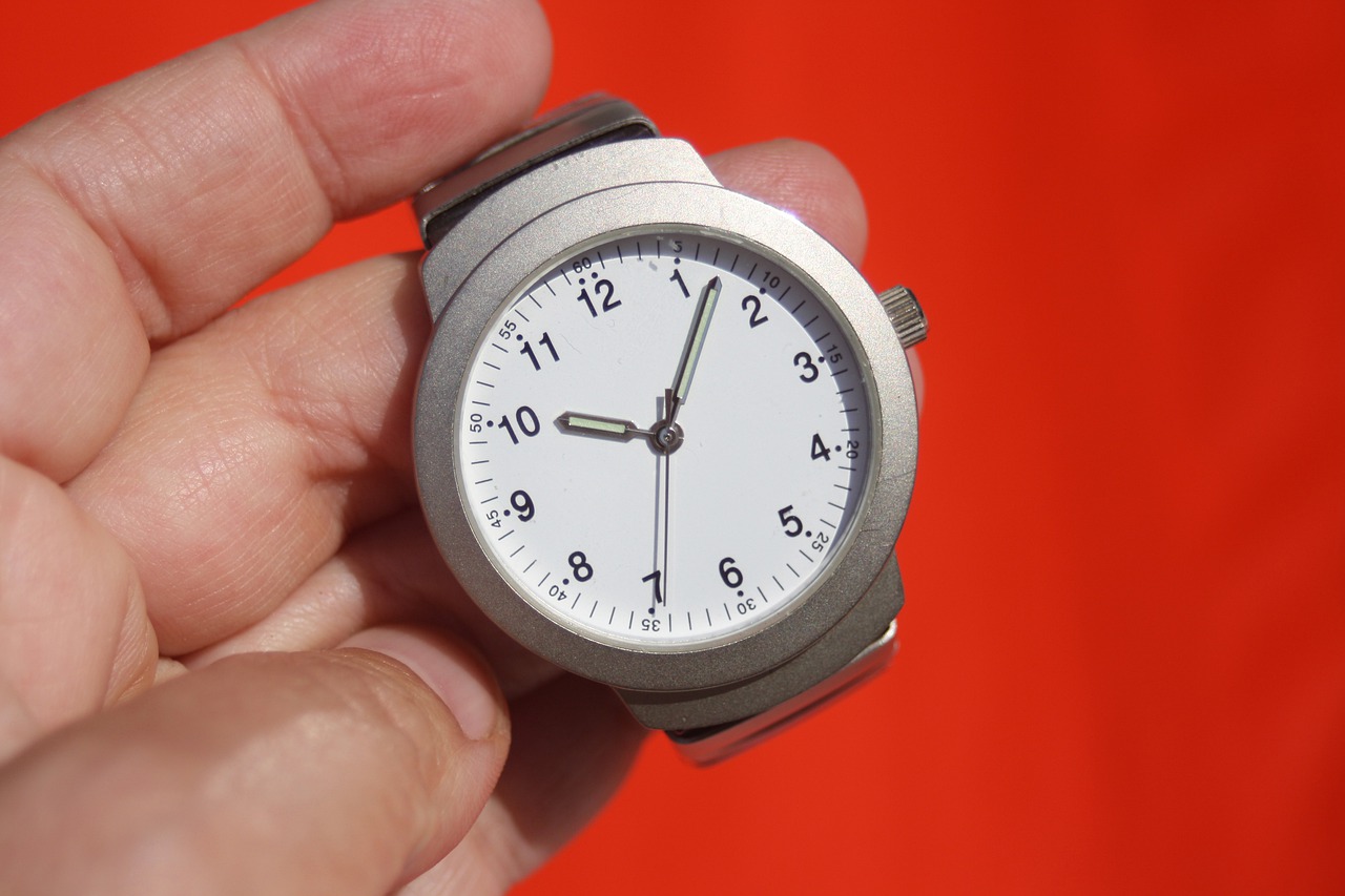 Time tracking - hand holding a watch showing 5 past 10